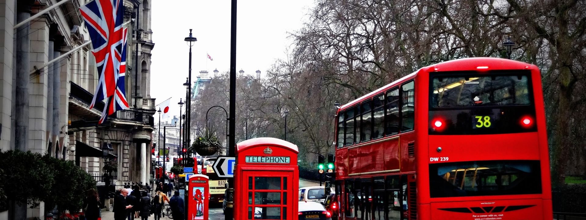 Union Jack flags, a red telephone box and a red London bus on a central London street